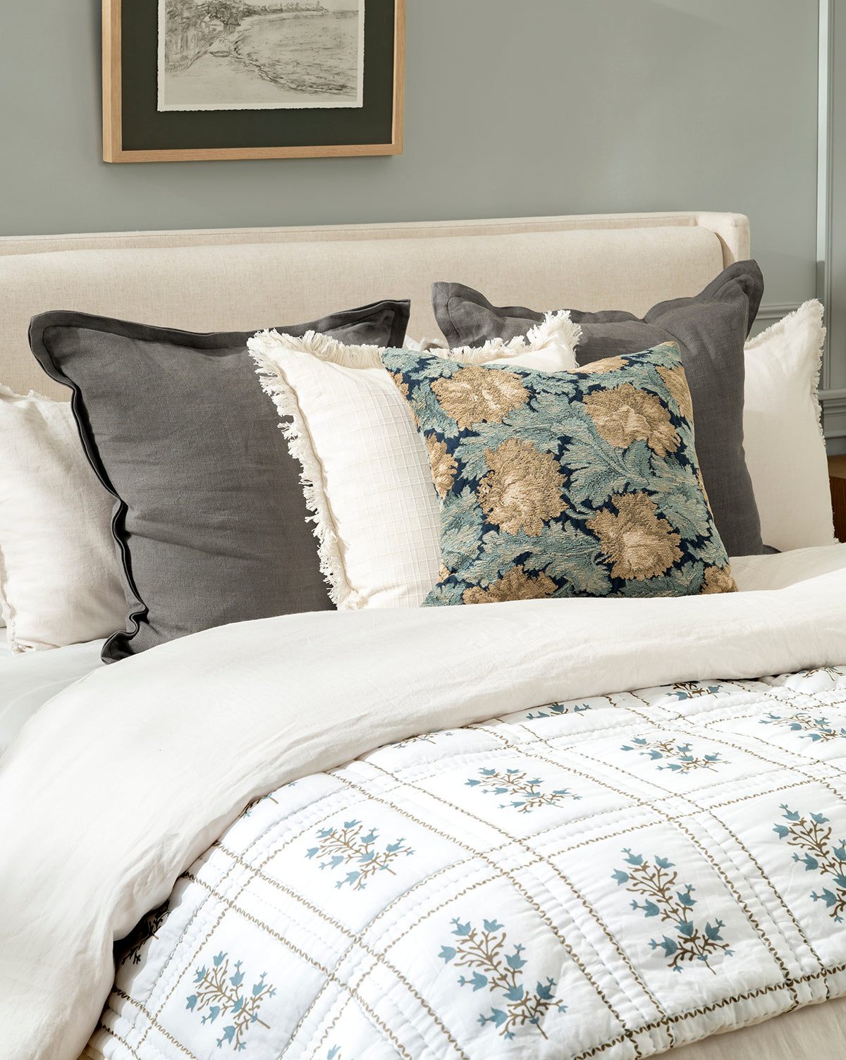 The Atherton Quilt displays subtle handmade artistry, while heirloom bedding adds charm beneath framed art above the headboard, by McGee & Co.