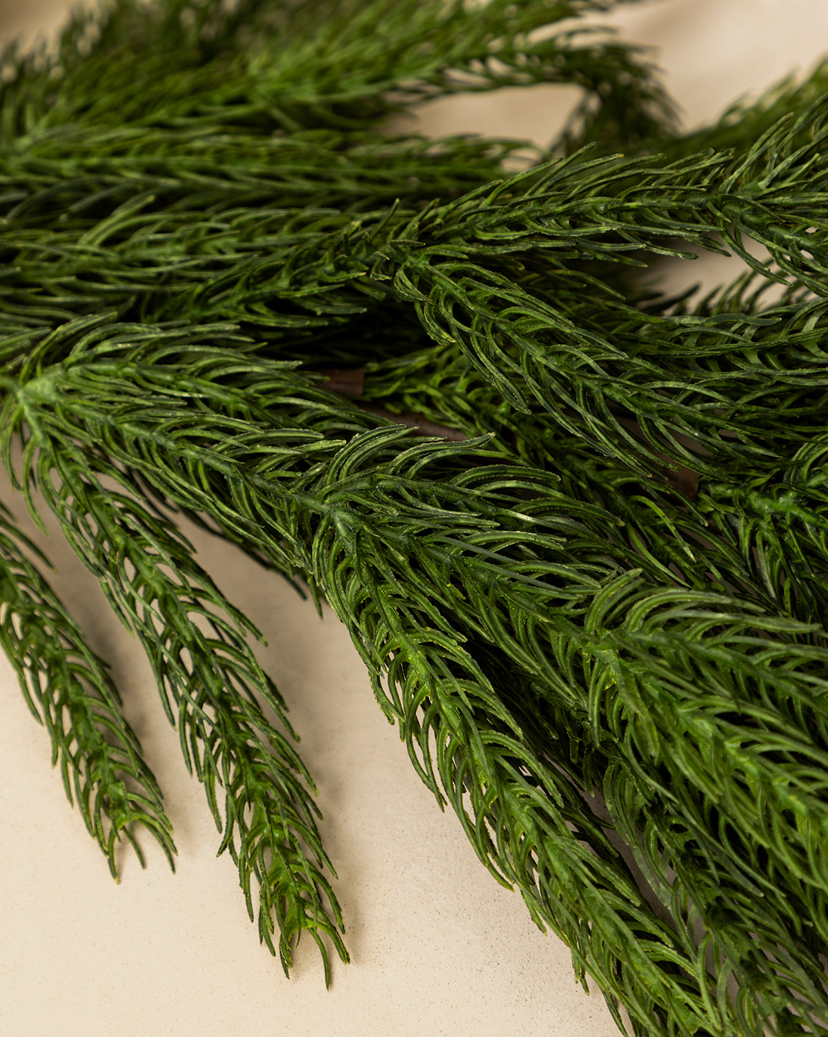 Several sprigs of fresh rosemary, with their dense, needle-like leaves, evoke the lifelike look of the 6' Norfolk Pine Faux Garland—perfect for inspiring holiday greenery decor, by McGee & Co.