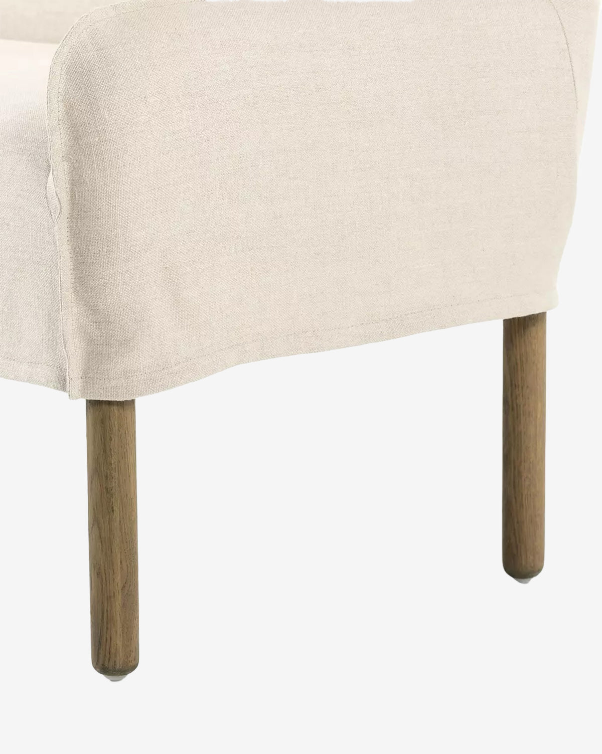 The Aiken Slipcover Bench features beige linen upholstery, a simple curved backrest, and visible wooden legs, by McGee & Co. Its cushioned seat provides added comfort, complementing the bench’s clean design against a white background.