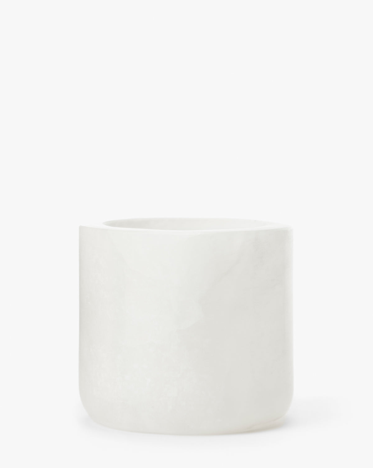 The Alabaster Tea-light Holder is a simple, cylindrical cup made of white marble with a smooth matte finish, perfect as an elegant décor piece or candle holder.