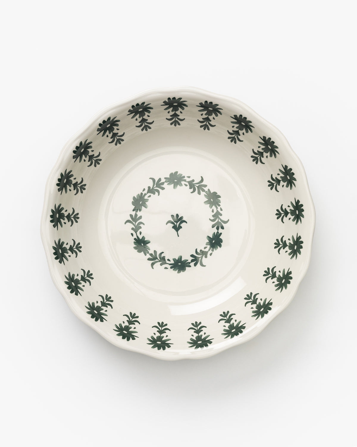 The Alba Melamine Serving Bowl is round and white with a scalloped edge, featuring a green floral motif along the rim and a central circular floral design, shown against a plain white background by McGee & Co.