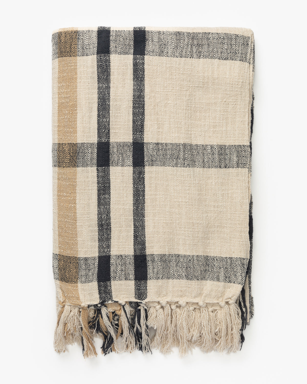 The Raj Albright Plaid Throw, beige cotton with black and tan plaid stripes and fringed tassels, is neatly folded on a white background, McGee & Co.