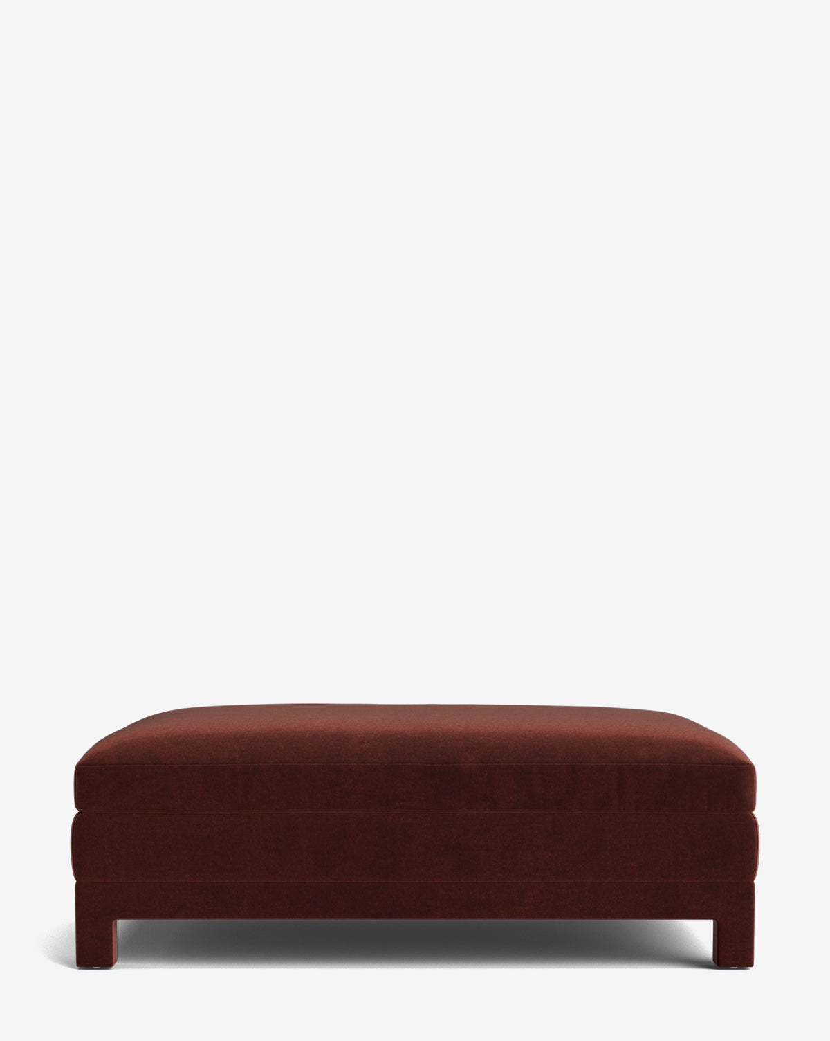 The Appoline Ottoman is a rectangular, dark red modern piece with a low profile and short legs, shown against a plain white background by McGee & Co.