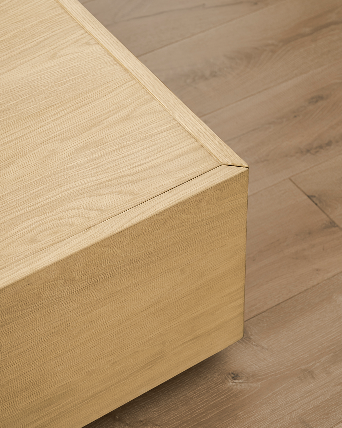 Close-up of the Bentley Coffee Table corner on a wooden floor, showcasing its smooth finish and natural wood grain, complemented by the modern design and quality craftsmanship, by McGee & Co.