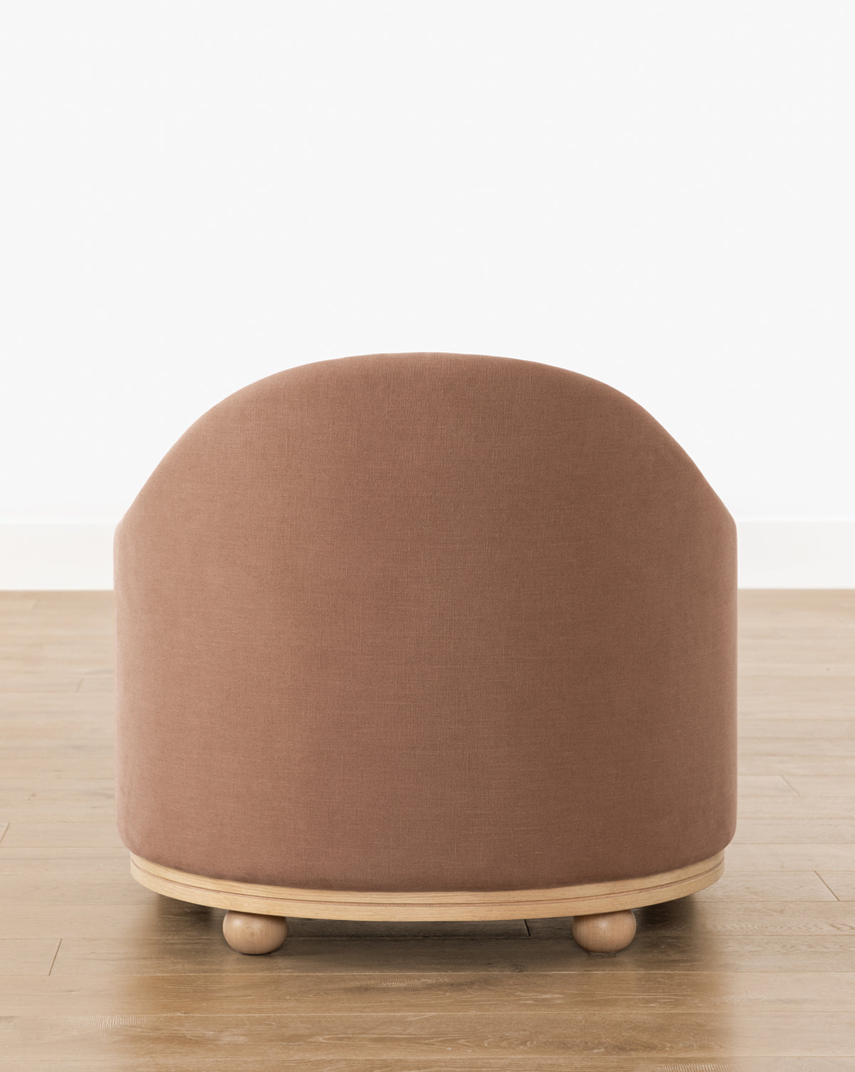 The Bunnell Lounge Chair (Ready to Ship) features a rounded, modern-traditional design with muted pink upholstery, a light wood base, and small round feet—perfect for any space with its clean lines and timeless appeal, by McGee & Co.