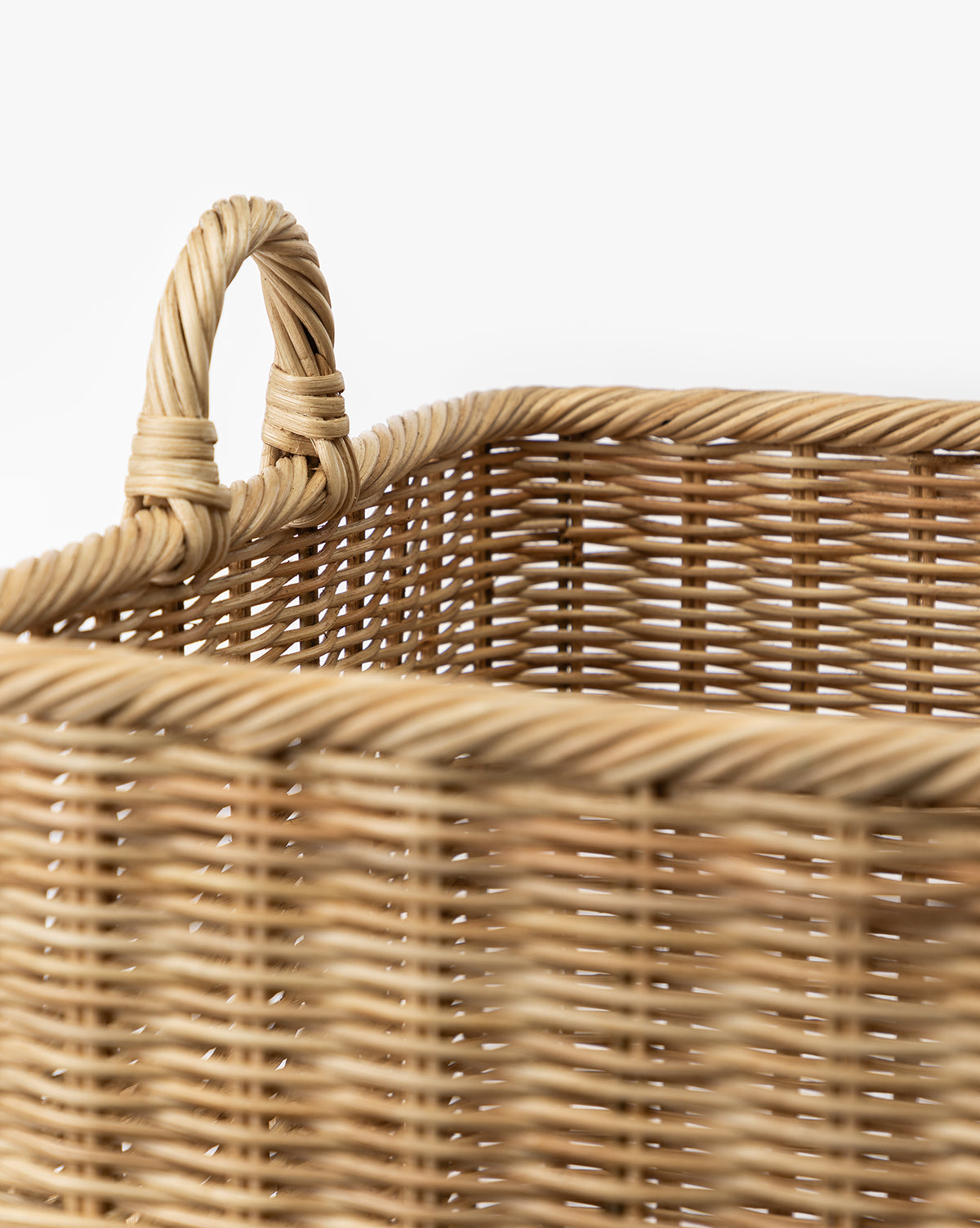 Close-up of the Chiara Laundry Basket, featuring a natural finish and sturdy handle, highlighting the detailed woven fiber texture and pattern against a plain white background, by McGee & Co.