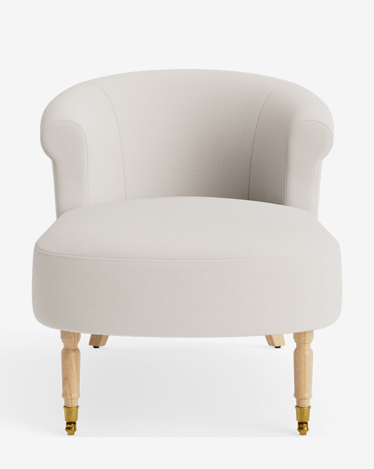 The Clemence Chaise is an upholstered, cream-colored armchair with a rounded backrest, rolled arms, and light wooden legs. The front two legs have small brass castors. The chair is shown against a white background, by McGee & Co.
