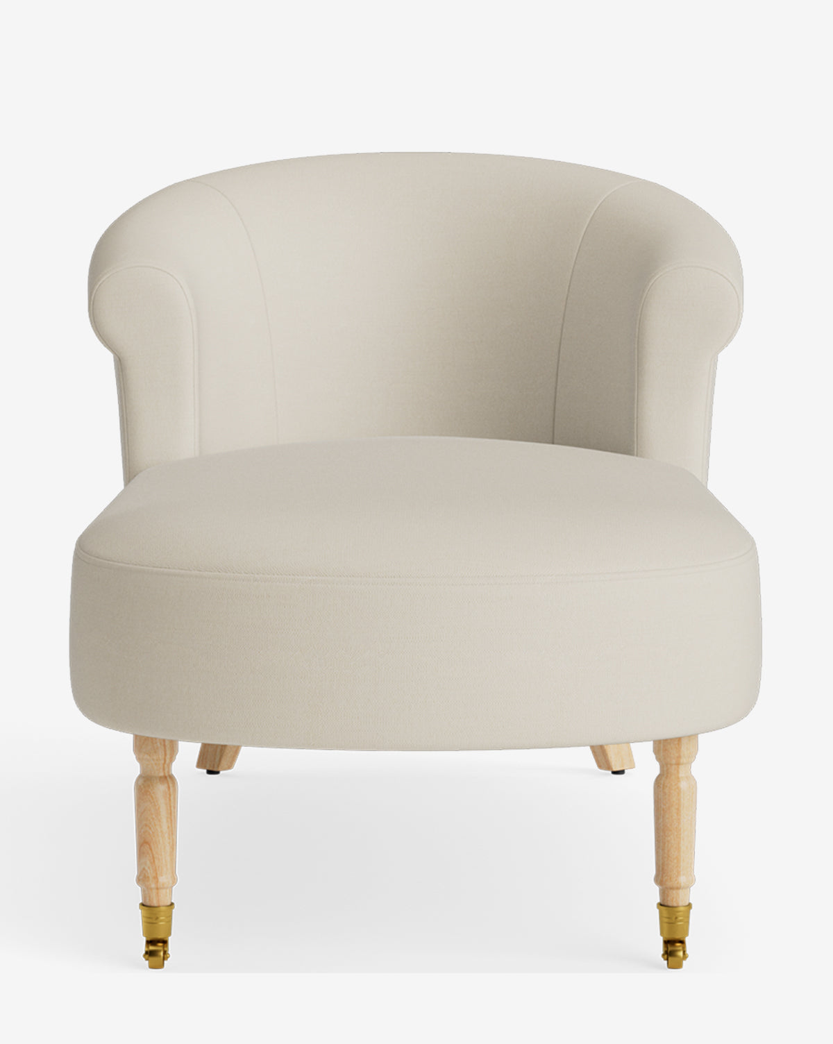 The Clemence Chaise is a cream-colored upholstered armchair with a curved backrest, rolled arms, and light wooden legs featuring brass caster wheels on the front, by McGee & Co. Inspired by classic chaise lounge design.