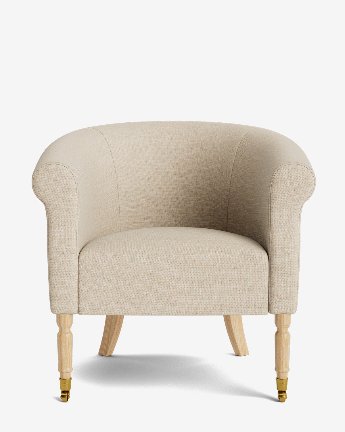 The Clemence Lounge Chair features beige upholstery, rounded arms and back, wooden legs, and brass caster wheels on the front legs, shown against a plain white background by McGee & Co.