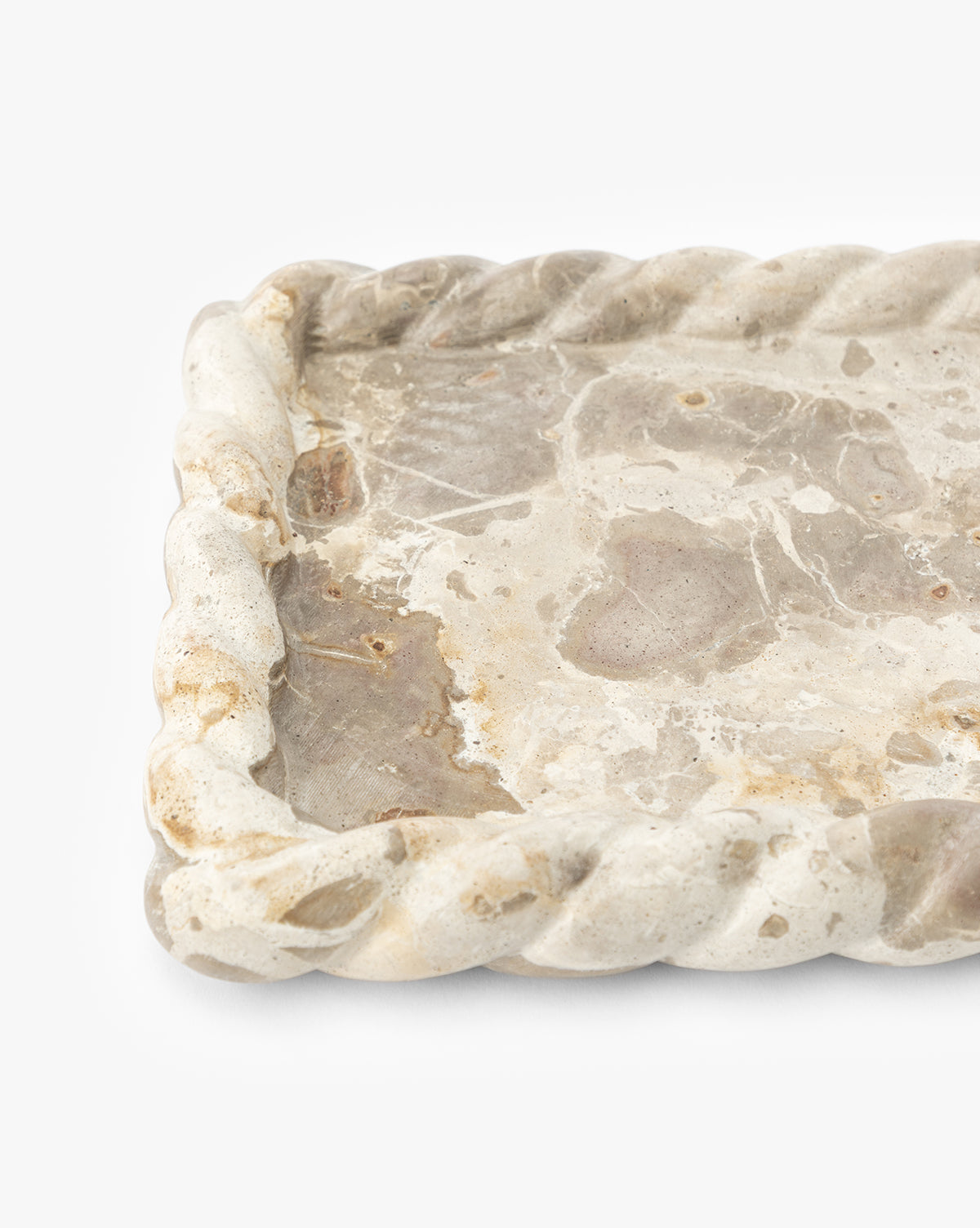 A close-up of the Cleves Marble Tray, a rectangular marble tray with twisted rope-like edges and natural beige and gray stone patterns. Ideal as a decorative tray or vanity organizer, shown against a white background, by McGee & Co.
