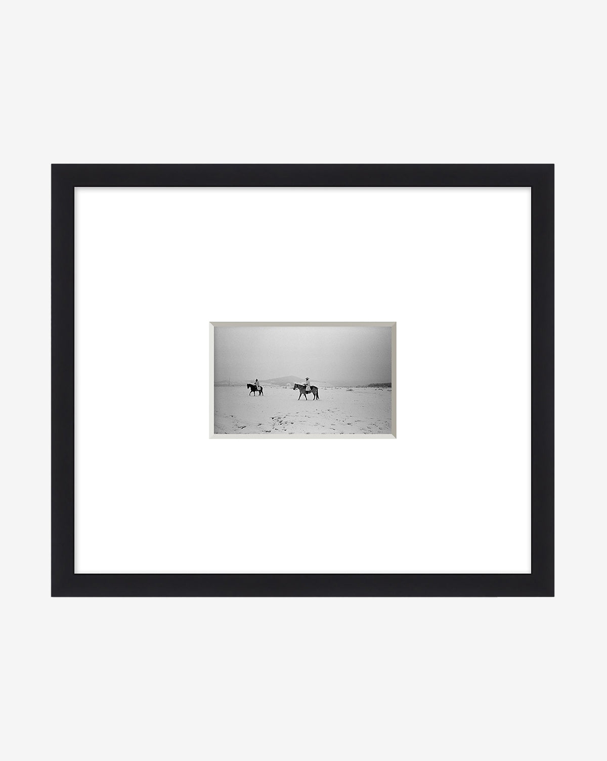 The Cold Voyage giclee print features two horseback riders crossing a flat landscape, centered within wide white matting and set in a sleek black frame, evoking the spirit of adventure, by McGee & Co.