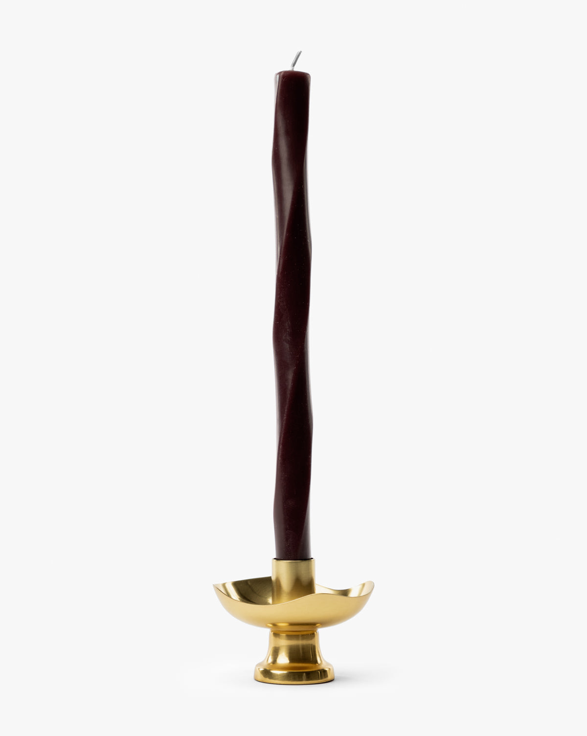A tall, dark burgundy twisted candle stands upright in the Cosima Taper Holder, an antique brass candle holder set against a plain white background—ideal for elegant decor, by McGee & Co.