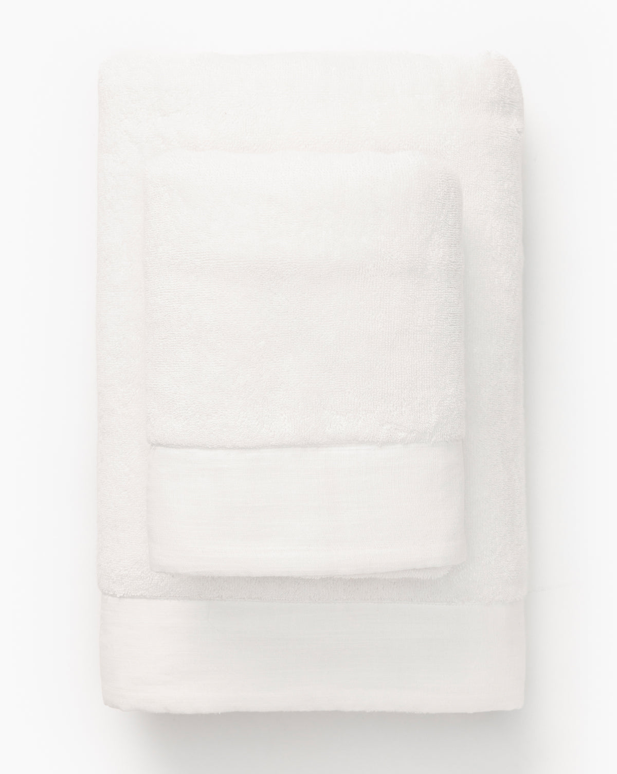 Two neatly folded white towels from the Dedra Bath Collection, one smaller and placed atop a larger one, are displayed on a plain white background.