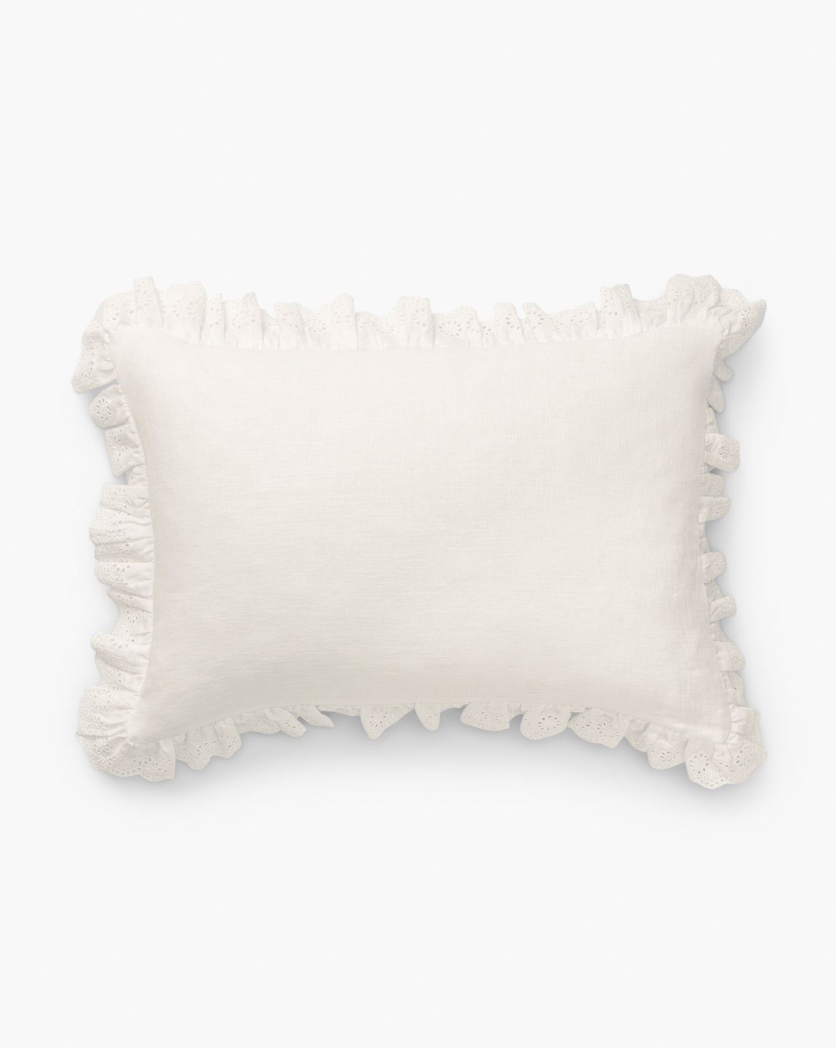 The McGee & Co. x Loeffler Randall Delilah Broderie Trim Pillow Cover features a textured white linen surface with decorative ruffled broderie trim, capturing the signature Loeffler Randall style against a crisp white backdrop, by McGee & Co.