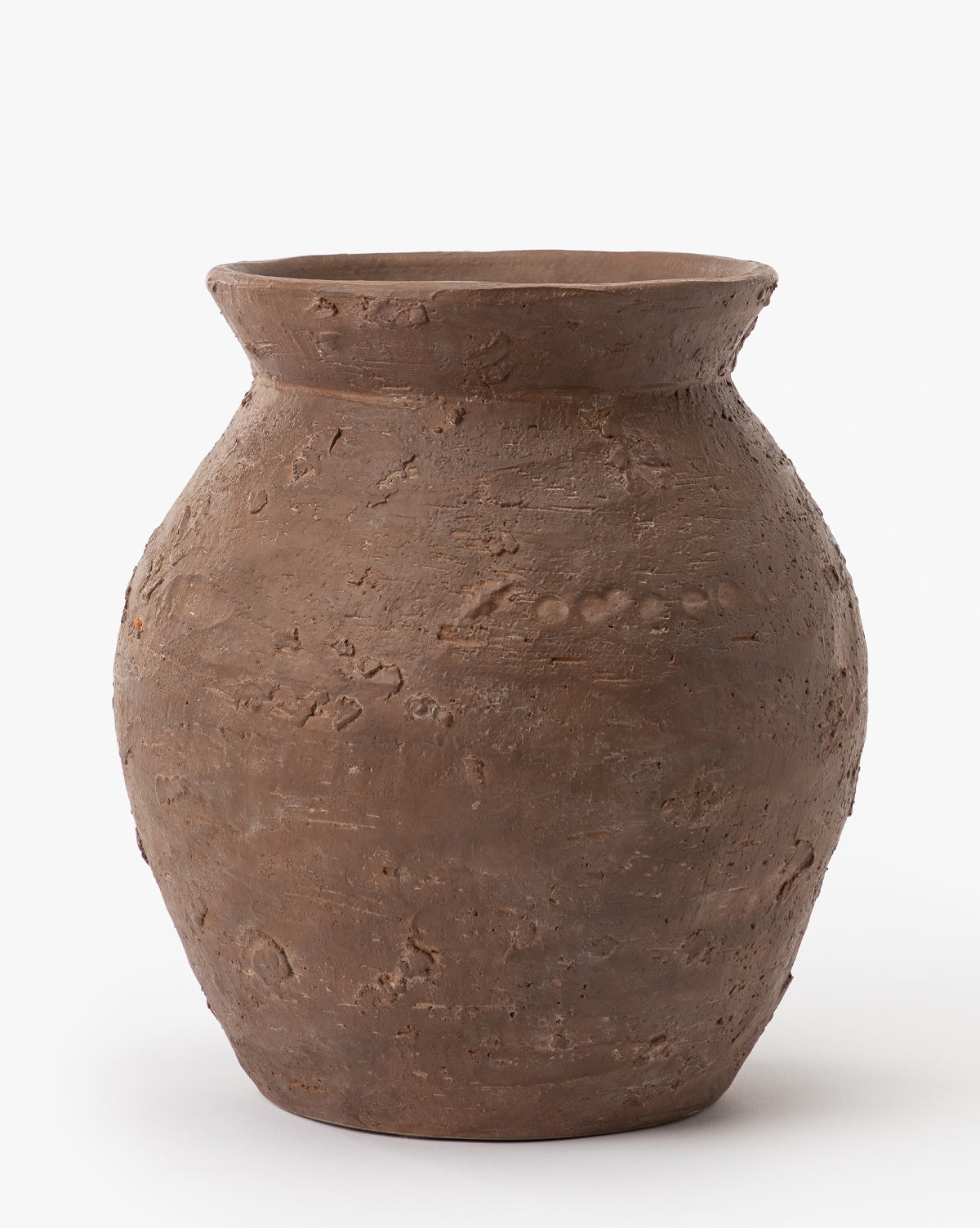 The Demetria Terracotta Vase has a wide, round body, narrow base, and slightly flared rim with a rough, textured finish. It is showcased against a plain white background.
