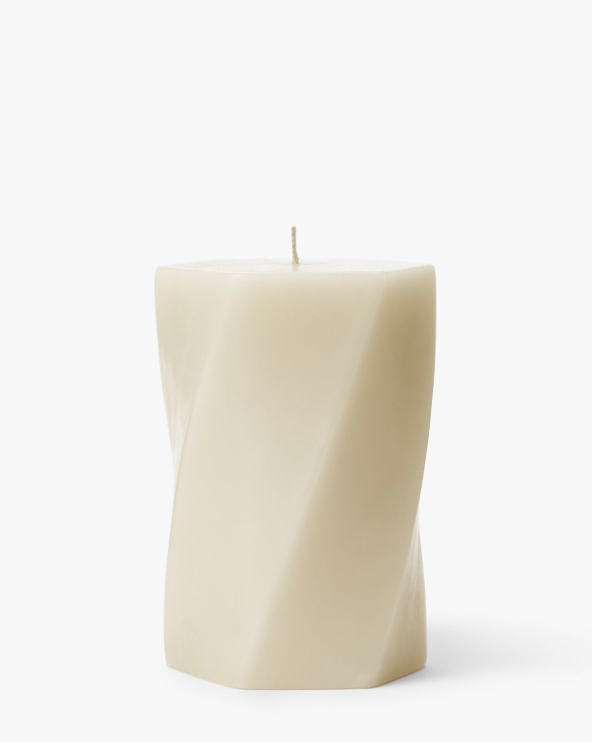 The Errol Wax Pillar Candle is a cream-colored, hexagonal candle featuring a subtle twisted design and a single wick on top, displayed against a plain white background by McGee & Co.