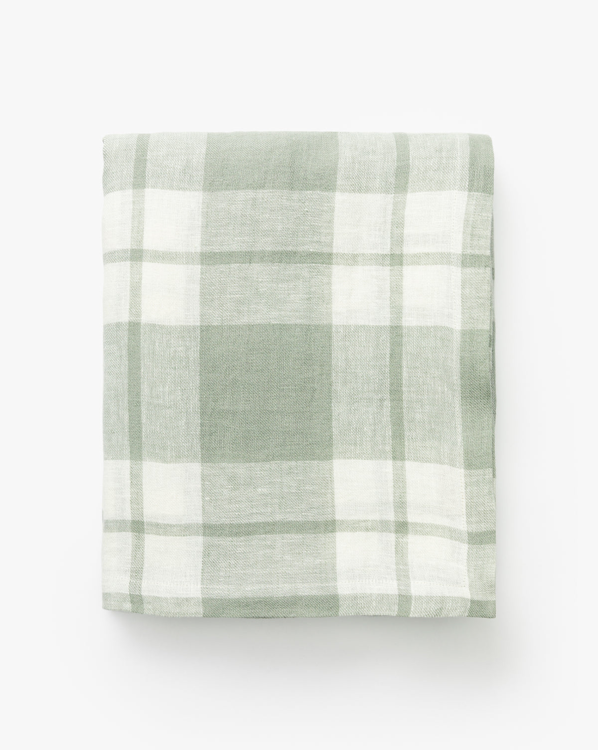 The Felix Plaid Tablecloth, neatly folded in light green and white plaid, is displayed against a plain white background by McGee & Co.