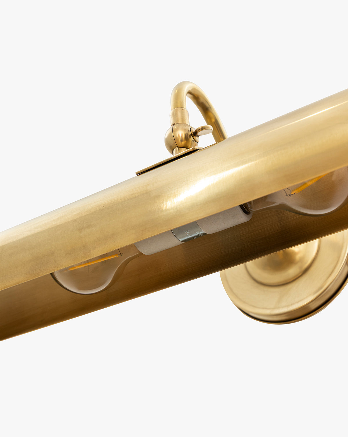 Close-up of the Gallery Picture Sconce, featuring a vintage-inspired cylindrical brass design with a burnished bronze finish. The image displays part of the bulb and mounting plate set against a white background, by McGee & Co.