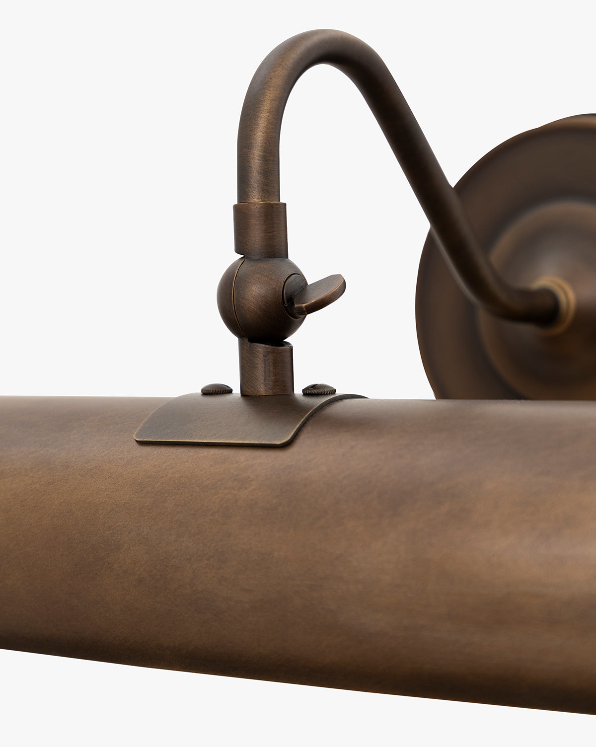 Close-up of the Gallery Picture Sconce in burnished bronze, with a cylindrical shade, curved arm, and adjustable knuckle joint, shown against a plain white background, by McGee & Co.