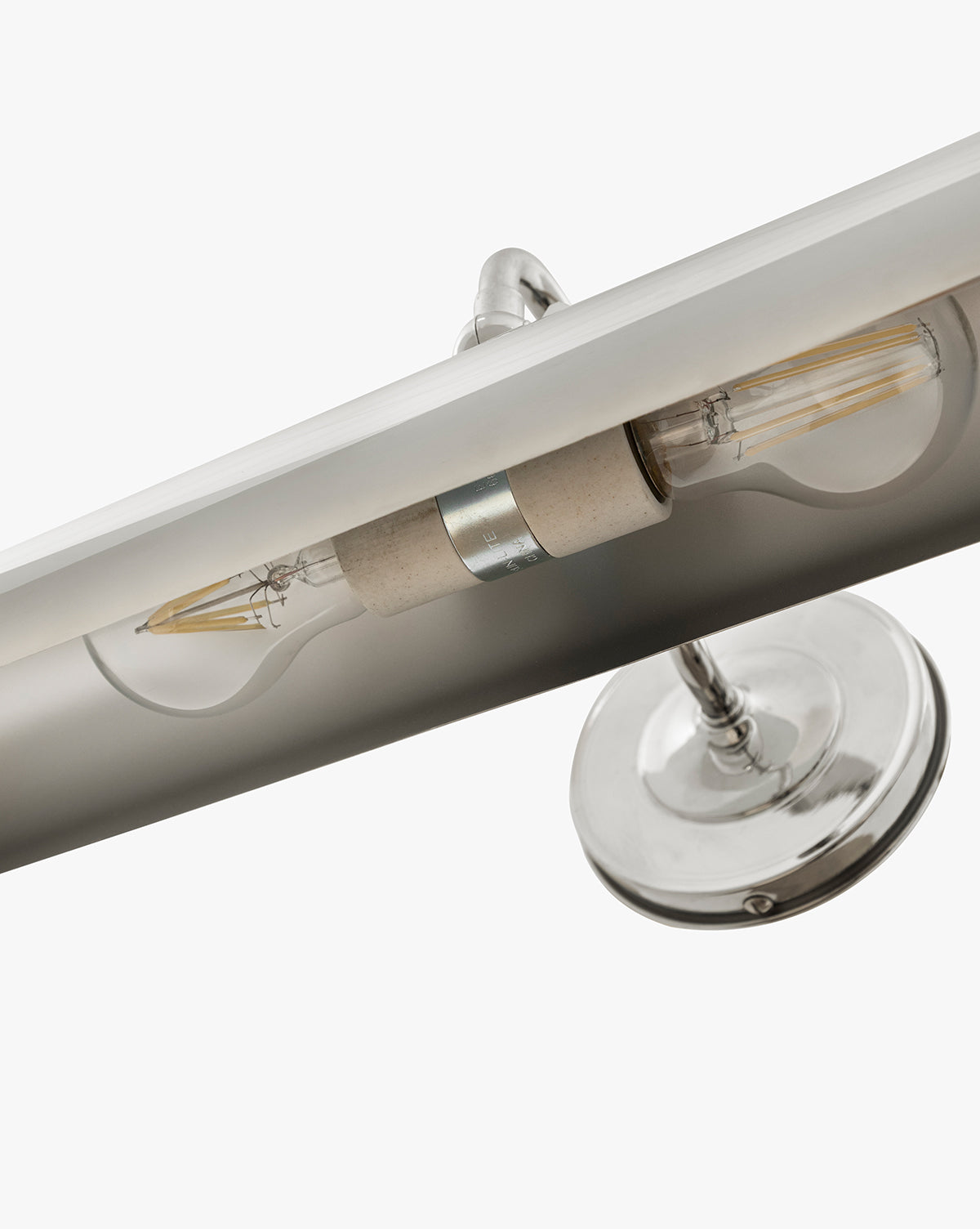 Close-up of the Gallery Picture Sconce with a burnished bronze metallic base and two exposed filament bulbs, shown against a plain white background, by McGee & Co.