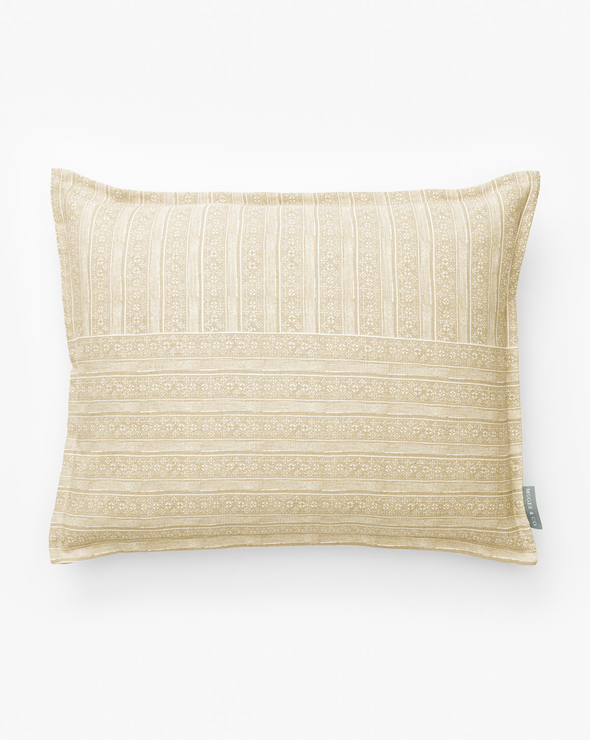 The Halstead Pillow Cover is a rectangular tan and white cover with subtle stripes and floral patterns, made from cotton and linen. It features a small fabric tag on the side and is shown against a plain white background by McGee & Co.
