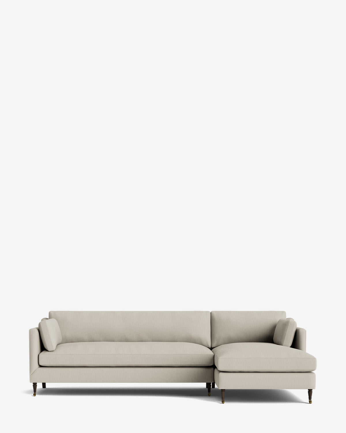 The Haverford Upholstered Right Chaise Sectional 113 is a modern, light beige sectional with wooden legs and two matching cylindrical pillows, shown against a plain white background, by McGee & Co.