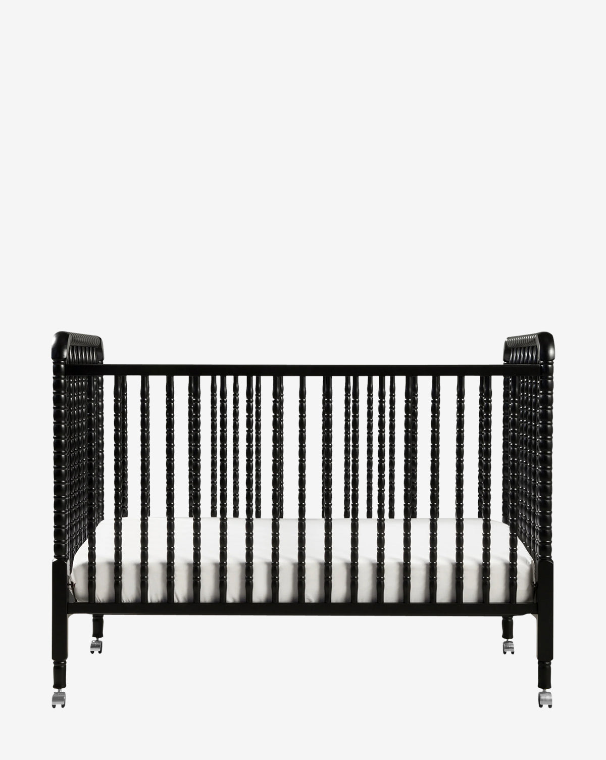 The Jenny Lind 3-in-1 Convertible Crib features a black vintage-inspired wooden frame with spindled sides, round posts, and comes with a white mattress, all set against a plain white background by McGee & Co.