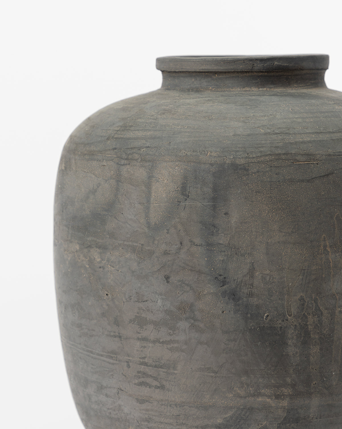 A close-up of the Jexa Vase, a unique round dark gray ceramic piece with a wide body, short narrow neck, and matte textured surface featuring subtle earthy patterns, set against a plain white background.