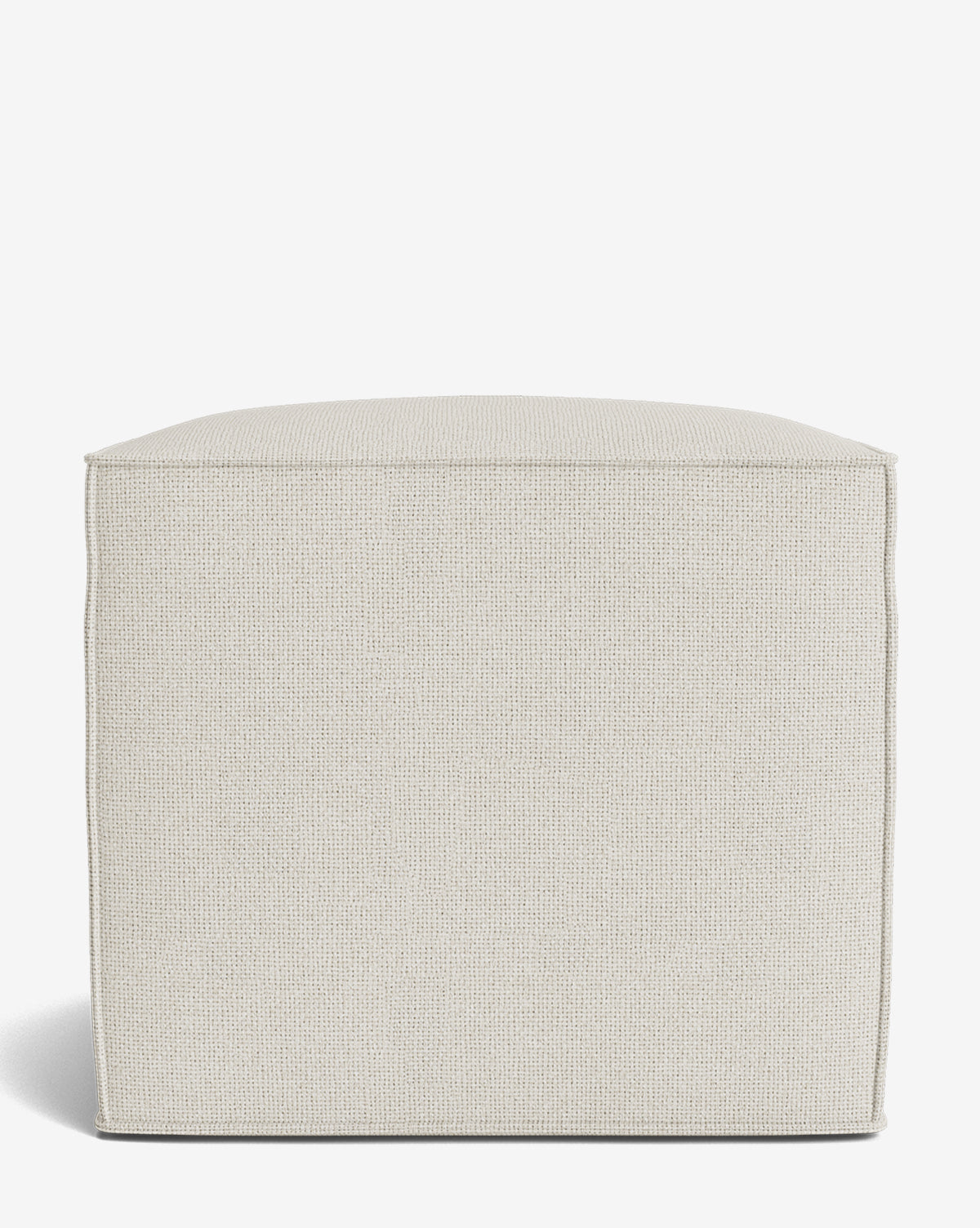 The Johannes Cube is a square, light beige fabric ottoman with a cushioned seat and textured surface. Its simple, boxy design features straight edges and soft corners, making it ideal for contemporary spaces. Shown against a white background by McGee & Co.