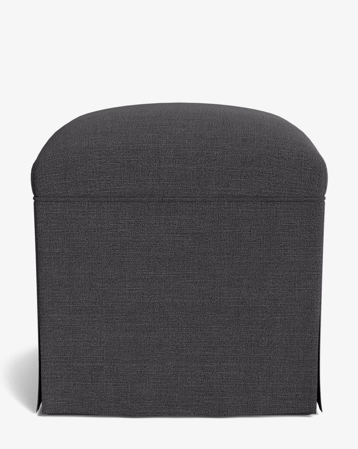 The Makerspalm Latimer Ottoman showcases a dark gray, rectangular form with a rounded cushioned top and skirted high-quality fabric cover, all set against a plain white background by McGee & Co.