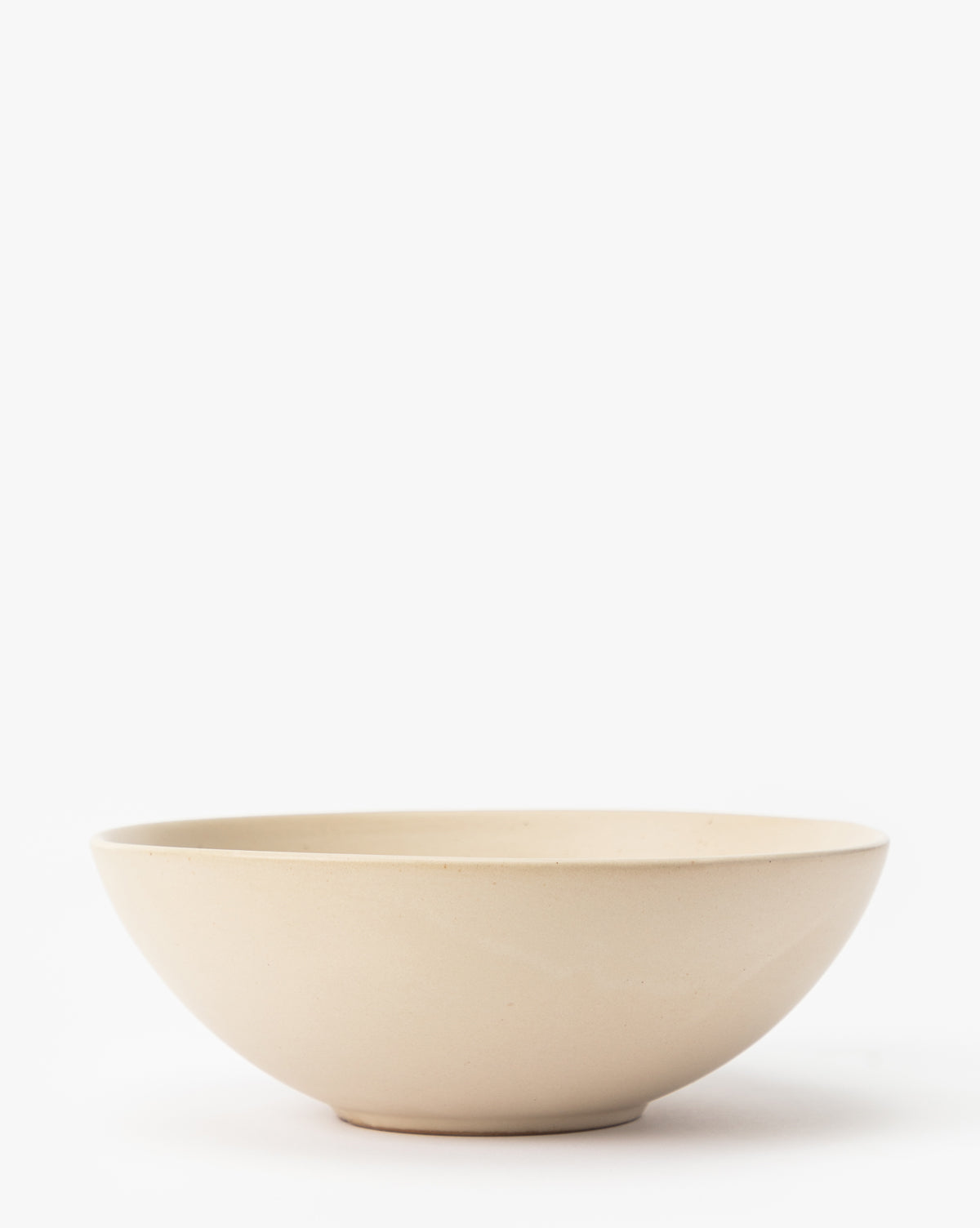 The Luana Bowl is crafted from glazed stoneware in a light beige tone with a smooth finish, displayed on a white background by McGee & Co.
