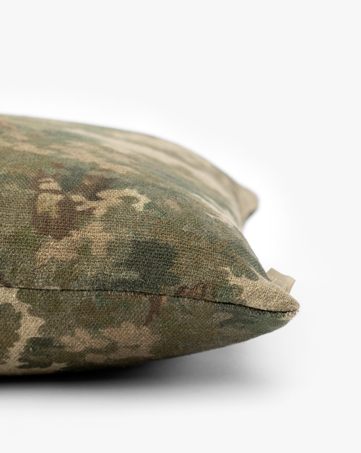 A close-up of the Lucetta Pillow Cover highlights its nature-inspired green and brown pattern, set against a plain white background by McGee & Co.