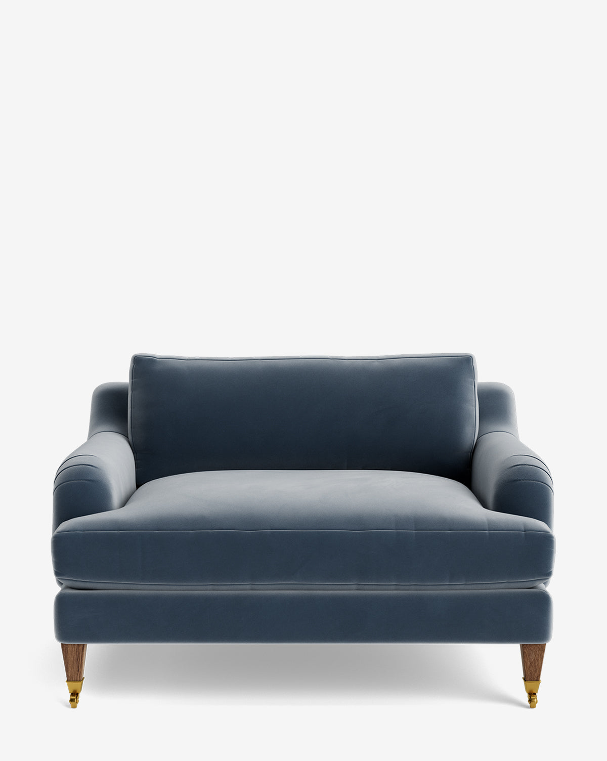 The Lucille English Roll Arm Chair and a Half is a plush blue velvet loveseat with down-wrapped cushions, rounded arms, and wooden legs with brass castors on the front two legs, set against a plain white background by McGee & Co.