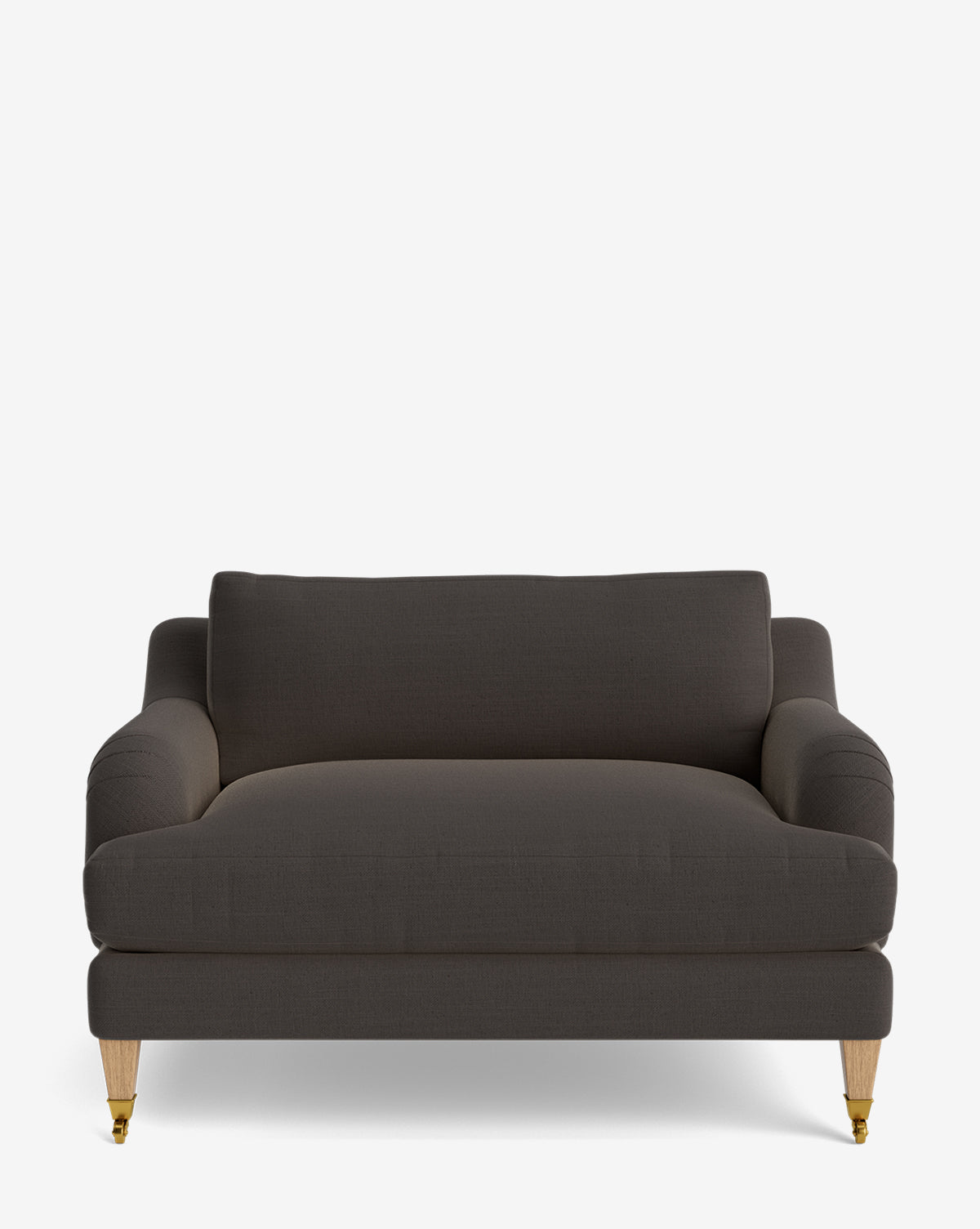 The Lucille English Roll Arm Chair and a Half is shown from the front in dark gray upholstery with wooden legs and brass castors. Its modern design includes curved armrests and a thick, down-wrapped cushion for added comfort, by McGee & Co.