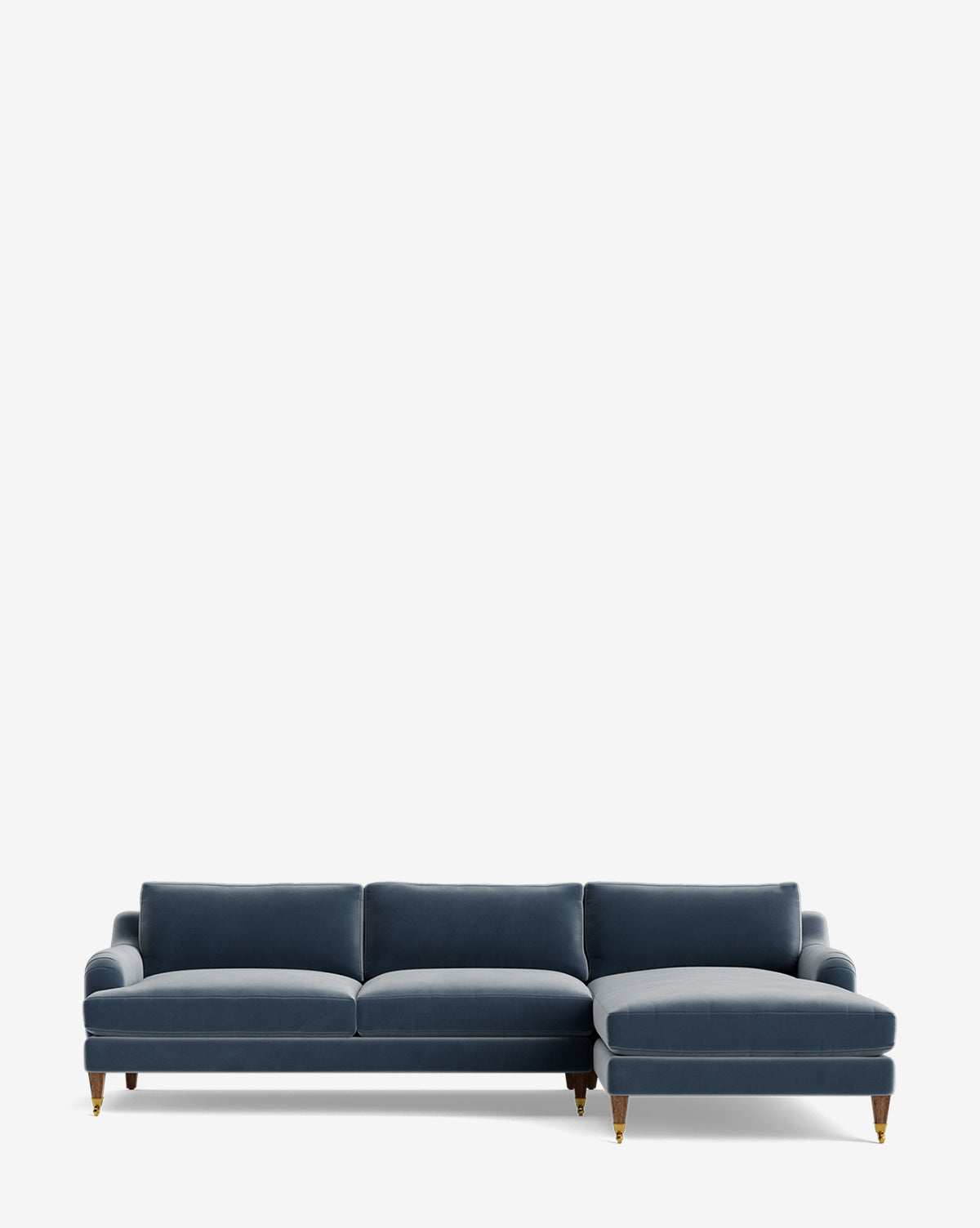The Lucille English Roll Arm Right Chaise Sectional 107 is a modern blue velvet sofa with three down-wrapped cushions, a customizable chaise, rolled arms, and wooden legs with brass caps, shown against a plain white background by McGee & Co.