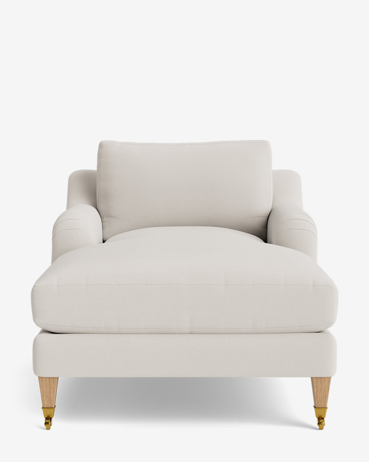The Lucille English Roll Arm Lounge Chair in light beige has plush down-wrapped cushions, rounded armrests, and wooden legs—two with brass casters—shown on a plain white background by McGee & Co.