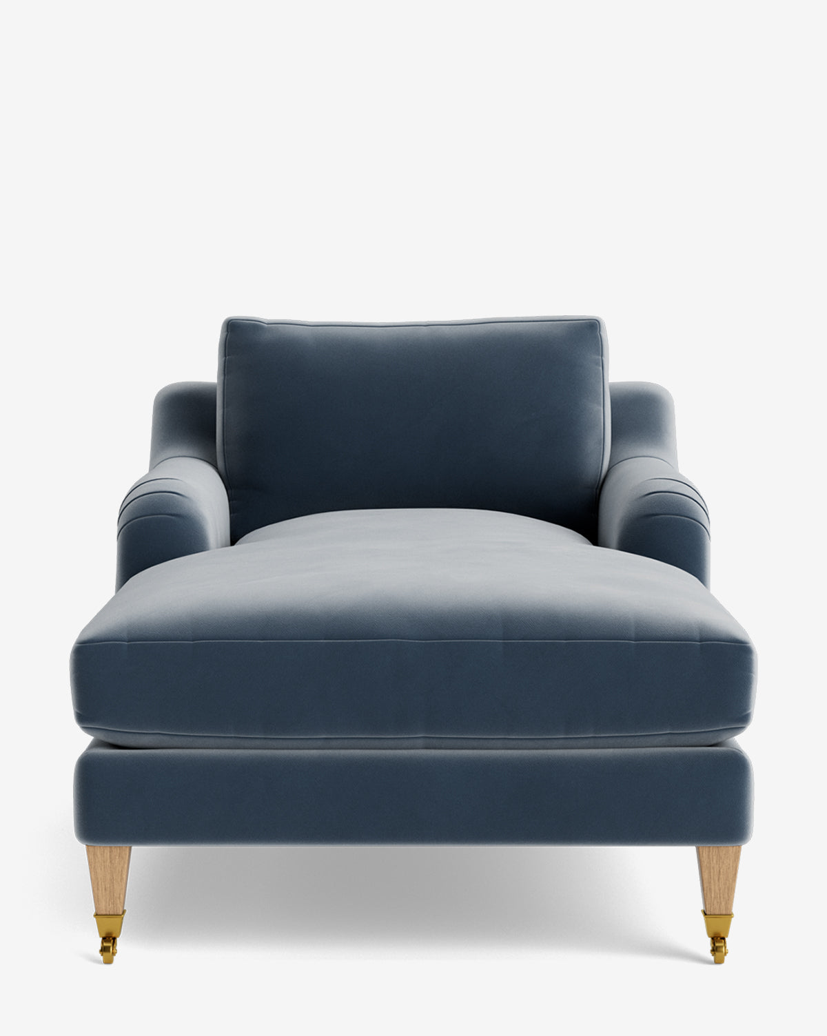 Front view of the Lucille English Roll Arm Lounge Chair in modern blue velvet, featuring a single down-wrapped cushion, low arms, and four wooden legs with brass casters on the front—set against a plain white background, by McGee & Co.