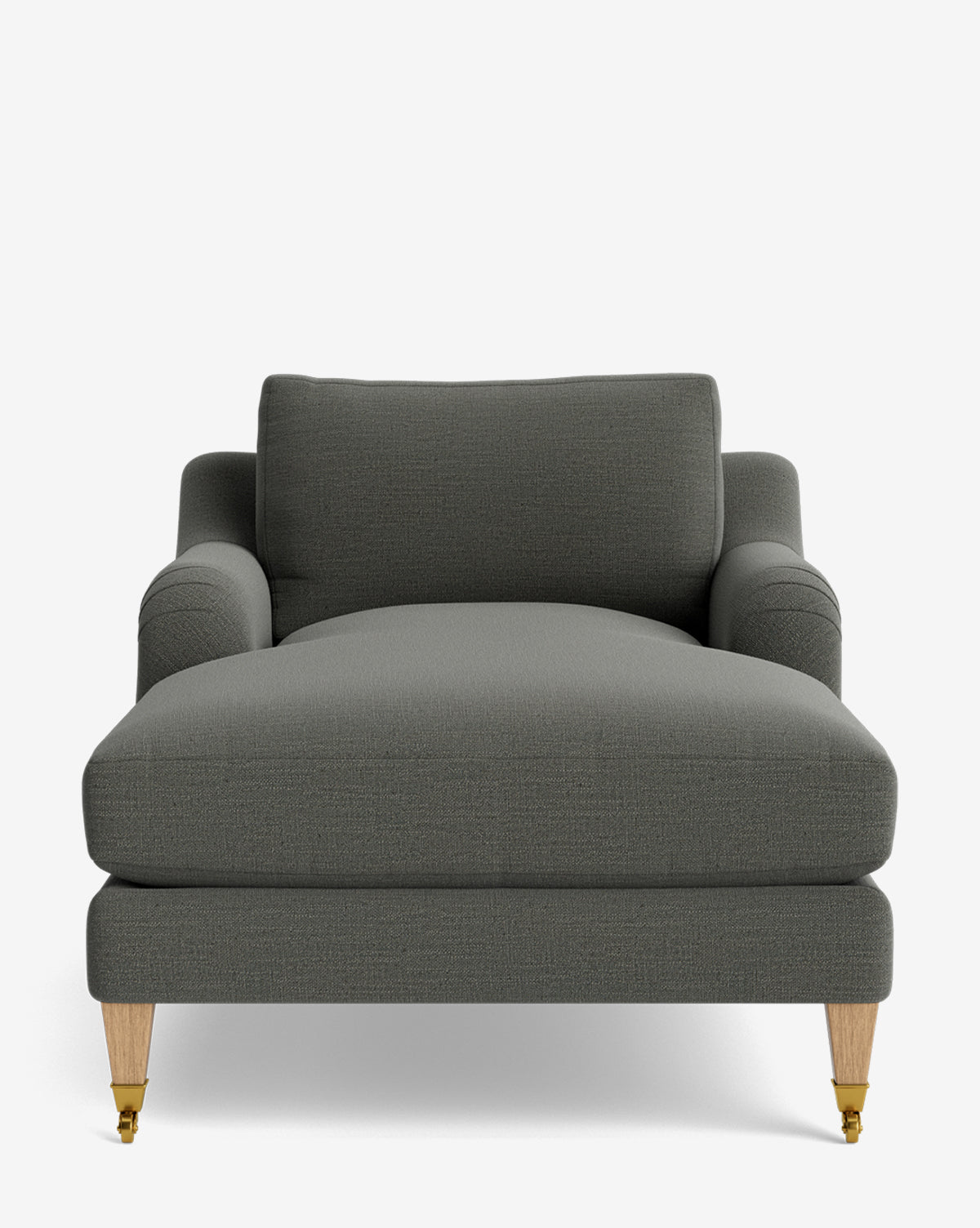 The Lucille English Roll Arm Lounge Chair features dark gray upholstery, a cushioned backrest, down-wrapped seat, rolled arms, and light wooden legs with small brass casters on the front two legs by McGee & Co.