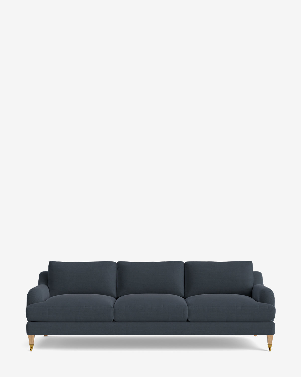 The Lucille English Roll Arm Sofa 90.5 is a dark blue, three-seater with down-wrapped cushions, gently rounded armrests, and wooden legs featuring brass-colored castors, shown against a plain white background by McGee & Co.