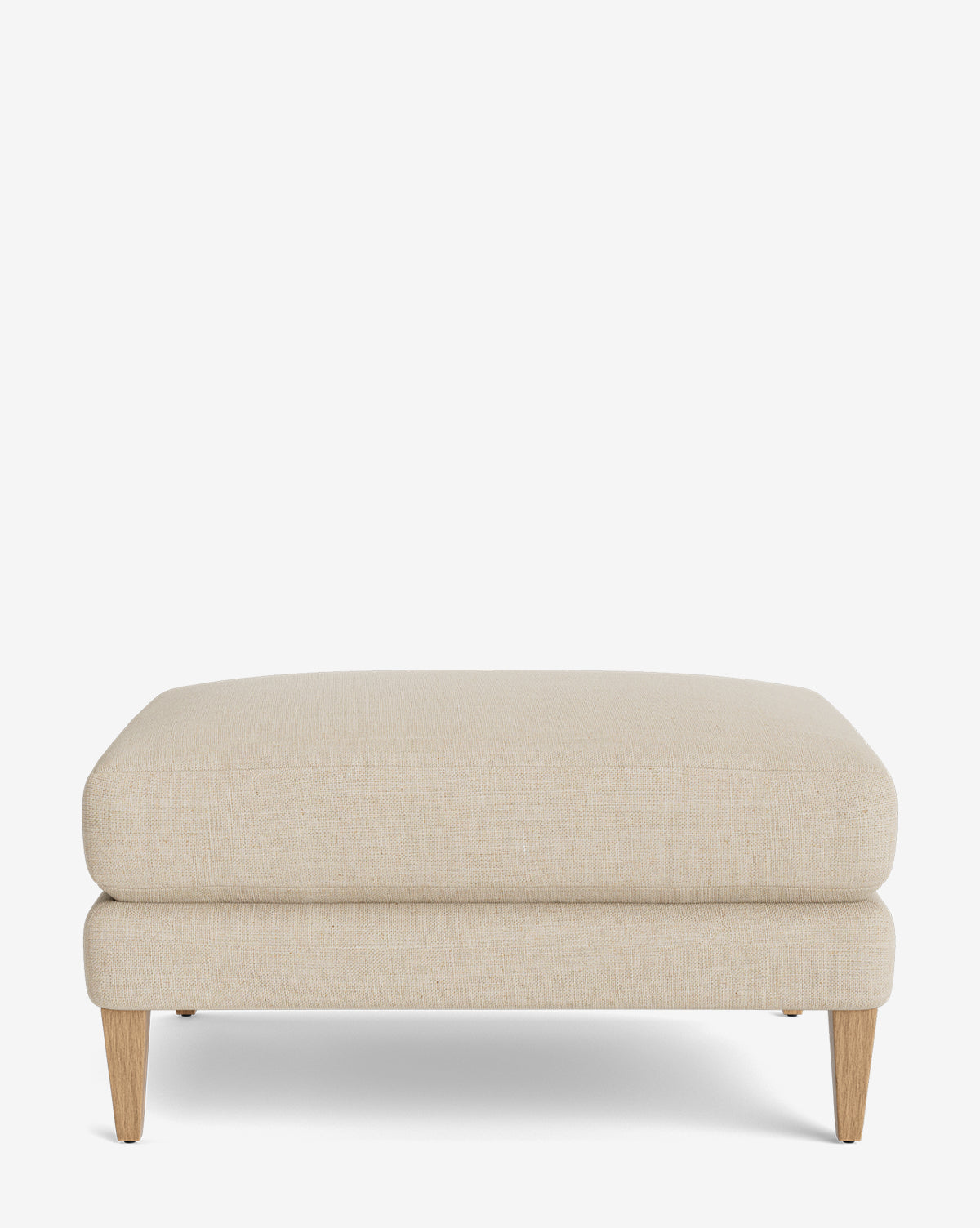The Lucille Ottoman is a modern rectangular ottoman upholstered in beige fabric with wooden legs, displayed on a plain white background, by McGee & Co.