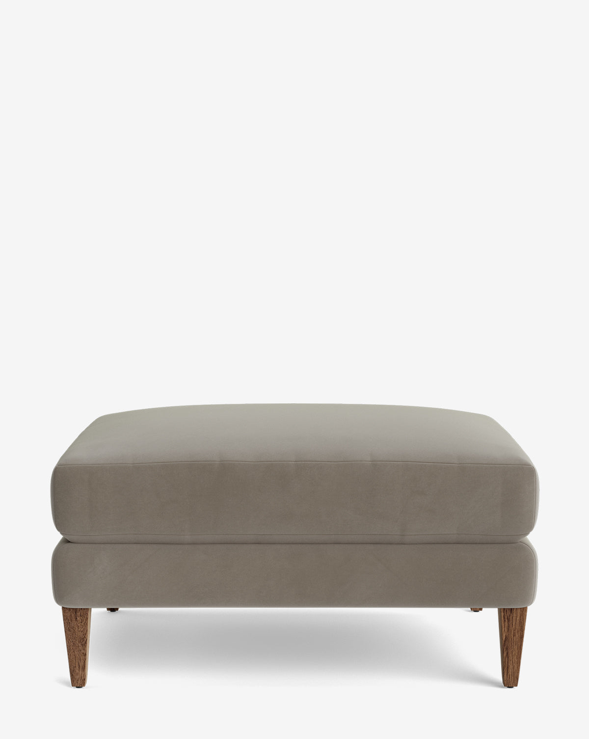 The Lucille Ottoman is a modern square ottoman with light gray upholstery and wooden legs, displayed against a white background, by McGee & Co.