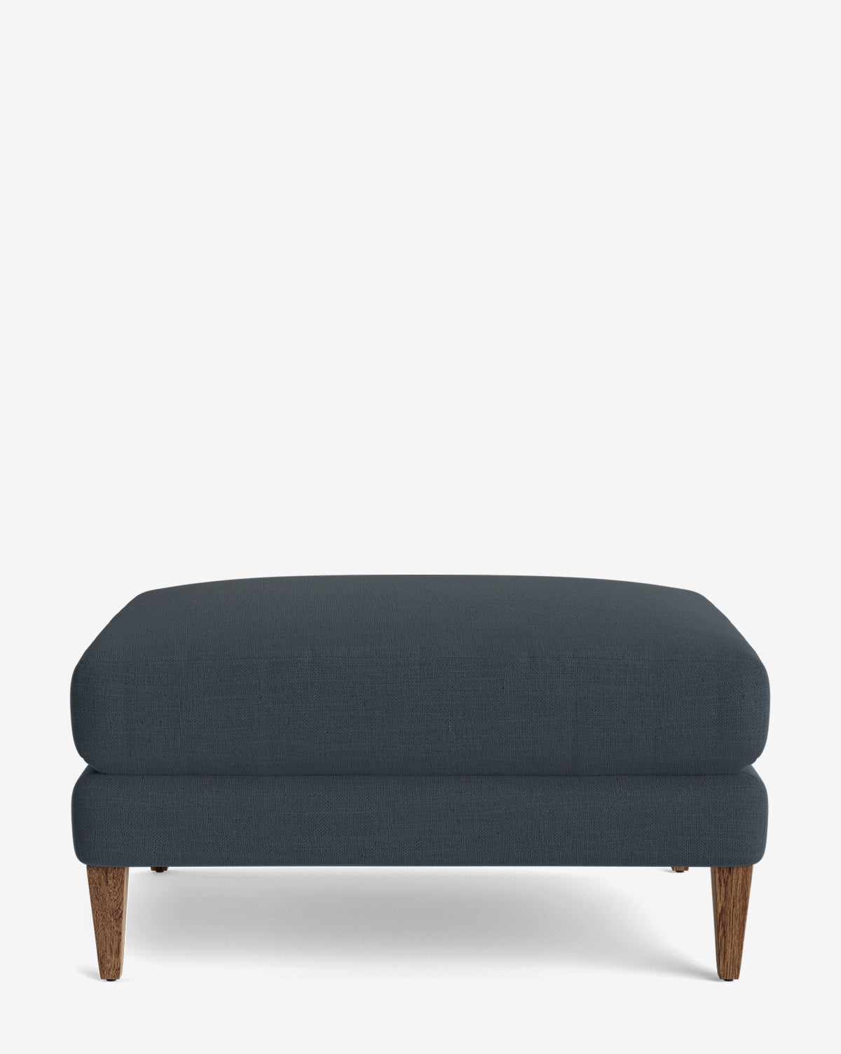 The Lucille Ottoman is a modern, dark blue rectangular ottoman featuring a cushioned top and wooden tapered legs, displayed on a plain white background, by McGee & Co.