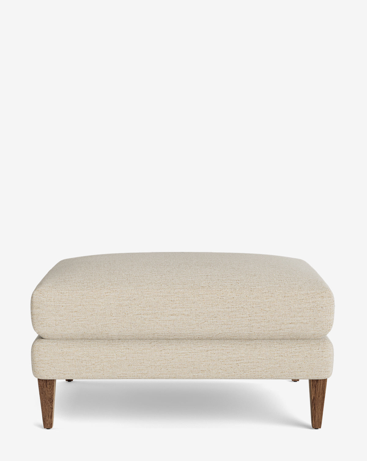 The Lucille Ottoman is a modern, rectangular piece with beige upholstery and wooden legs. Its clean lines and plush cushion make it ideal for any living space, shown here against a white background by McGee & Co.