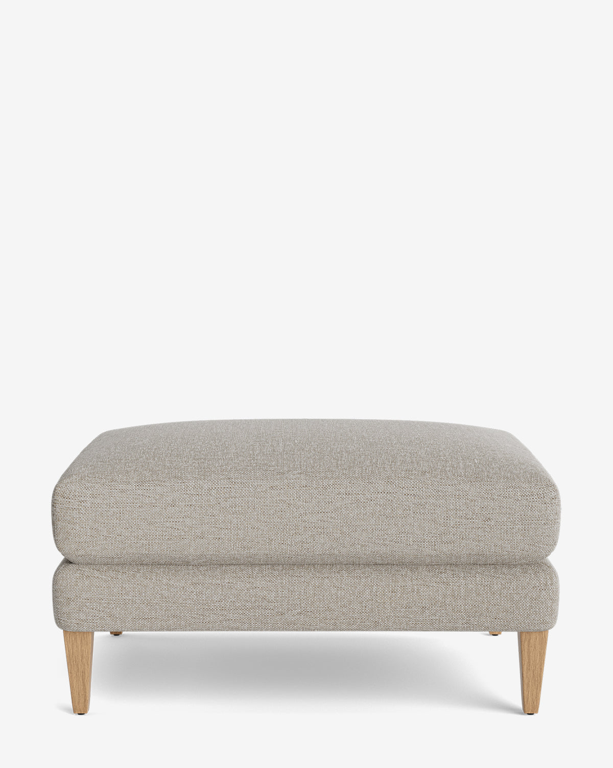 The Lucille Ottoman is a modern rectangular piece in light gray upholstery with a cushioned top and four light wooden legs, displayed on a plain white background, by McGee & Co.