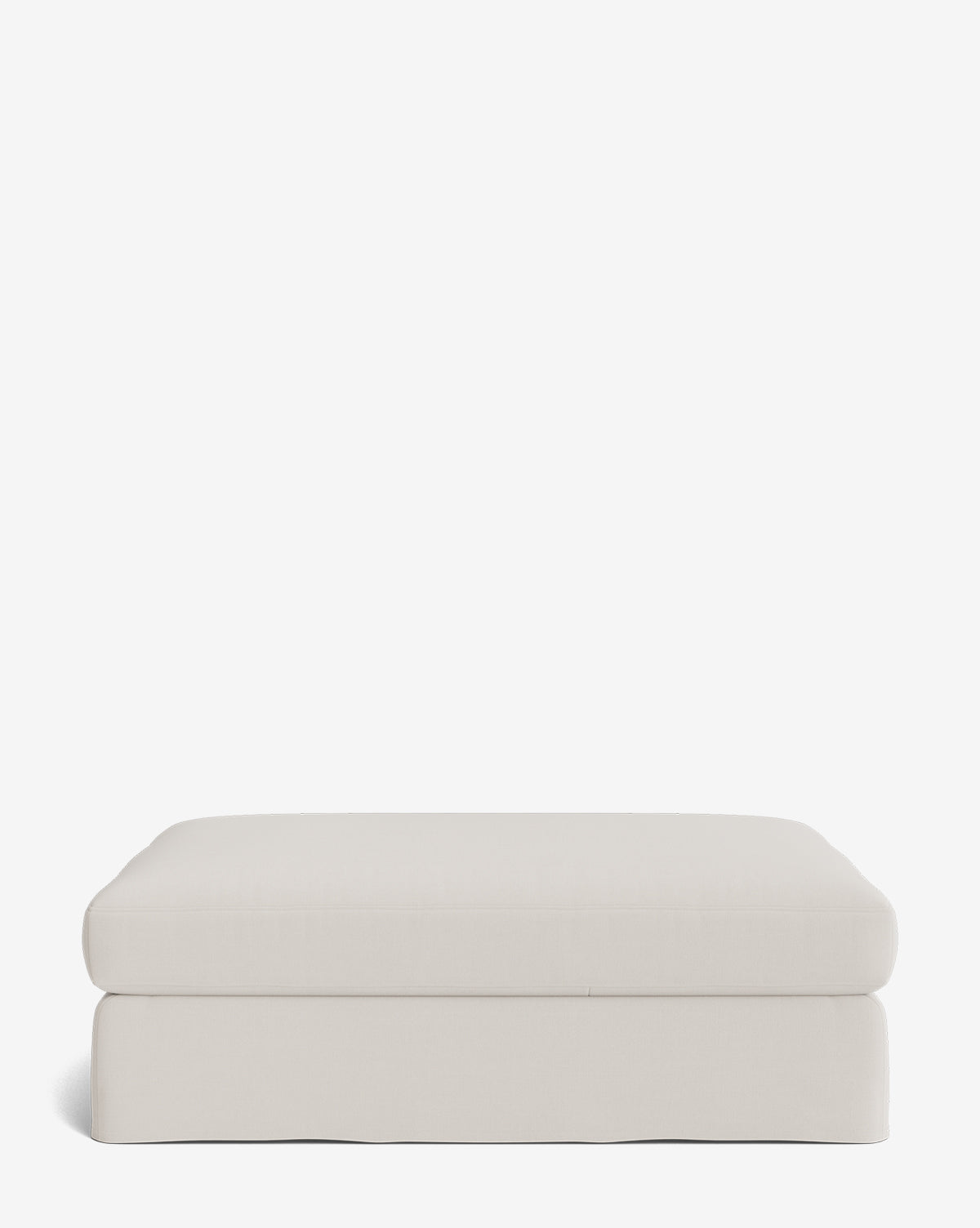 The Macy Slipcover Ottoman, in light beige fabric, features a smooth, simple rectangular design with a slightly rounded top and tailored base—an elegant addition to any living room, by McGee & Co. Shown against a plain white background.
