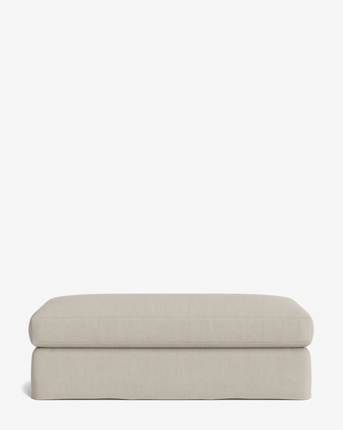 The Macy Slipcover Ottoman is a rectangular, light beige piece with rounded edges, shown against a white background—ideal as versatile living room furniture, by McGee & Co.