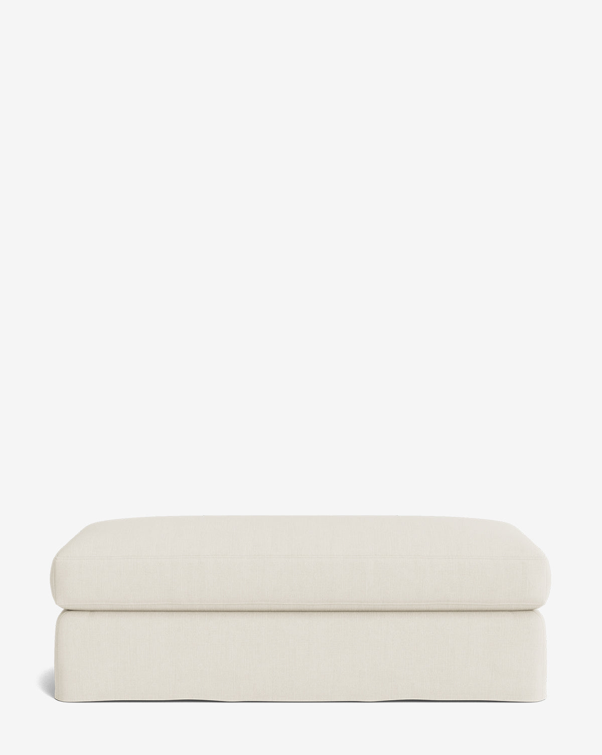 The Macy Slipcover Ottoman is a rectangular, cream-colored upholstered piece with a minimalist design—ideal for customizable living room decor—shown against a plain white background, by McGee & Co.
