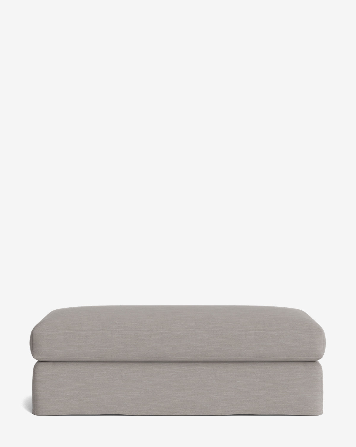 The Macy Slipcover Ottoman is a rectangular, light gray ottoman with smooth edges and a minimalist design, perfect for living room spaces, by McGee & Co. Shown against a plain white background.