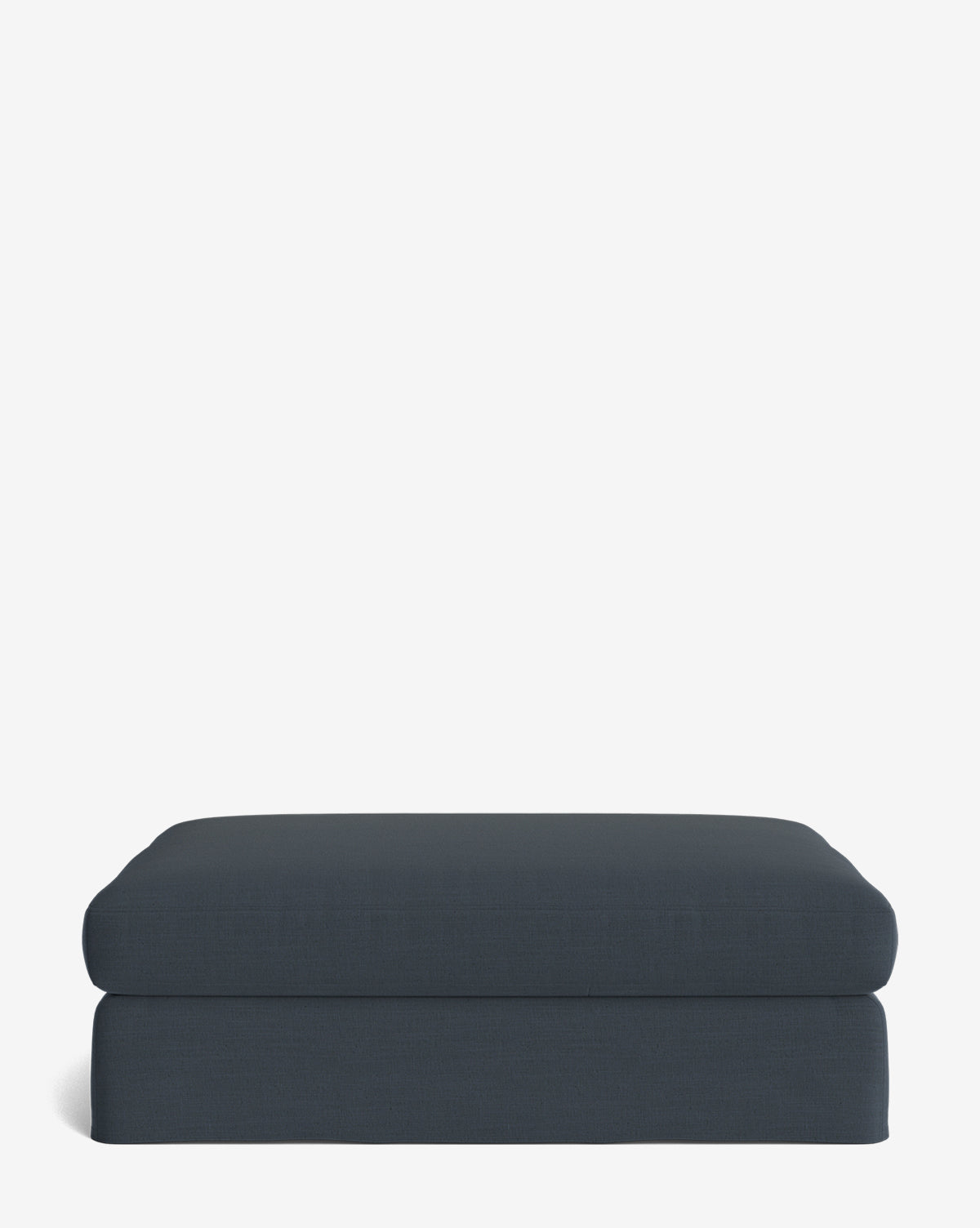 The Macy Slipcover Ottoman, a dark blue rectangle with soft, rounded edges and smooth fabric, sits on a plain white background. Its minimalist design is perfect for modern living room decor, by McGee & Co.