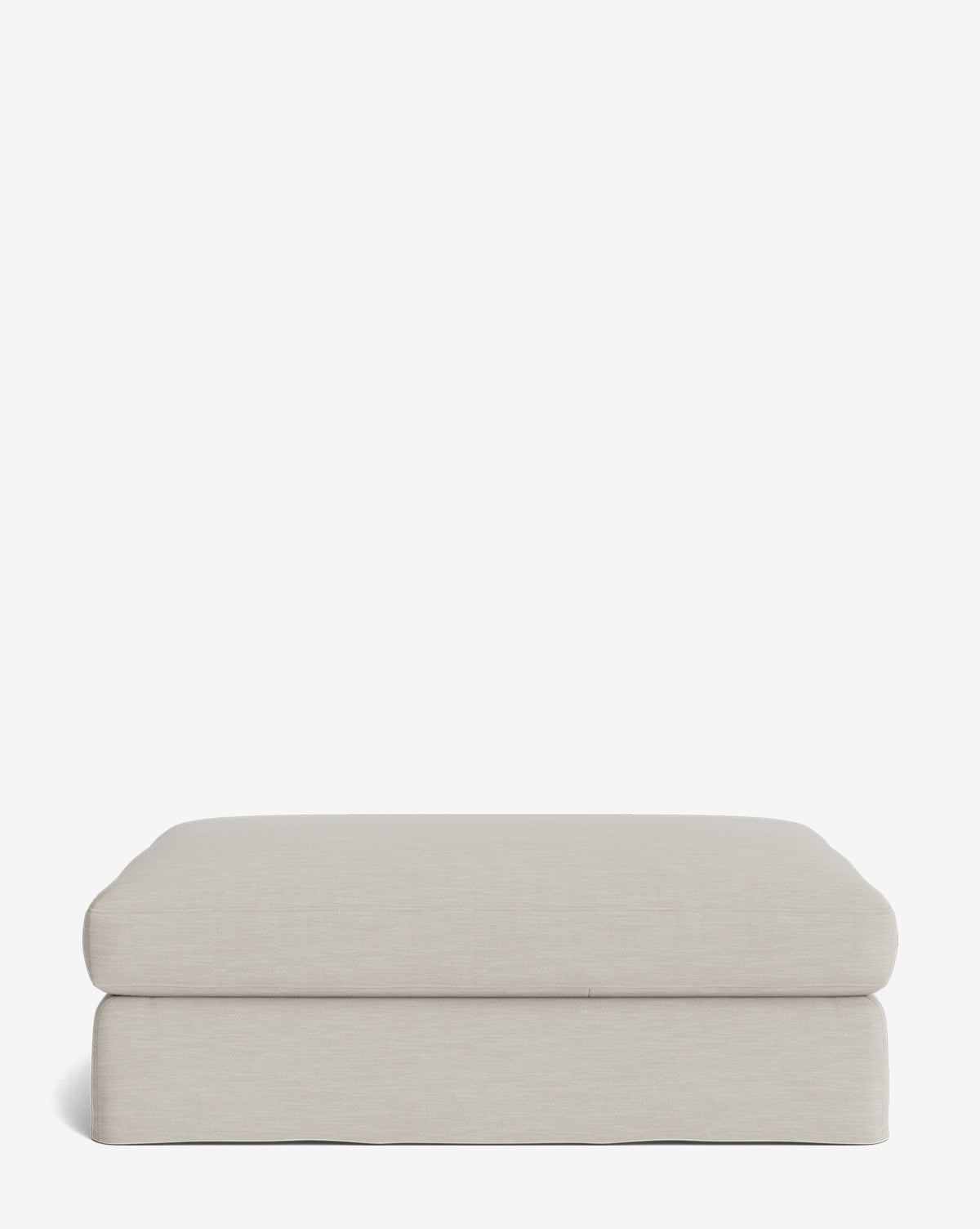 The Macy Slipcover Ottoman is a beige rectangular piece with a minimalist design and soft fabric upholstery, ideal for living rooms, shown against a plain white background, by McGee & Co.